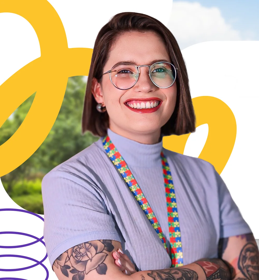 Mirelle Buêno sorrindo, de braços cruzados, com cordão de quebra-cabeça símbolo da causa do autismo